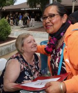 Alicia Jacob, an assistant to Senator Melissa Hurtado, presents a proclamation to Gina Sharra, widow of Kings County Deputy Allen Sharra, who died in the line of duty.